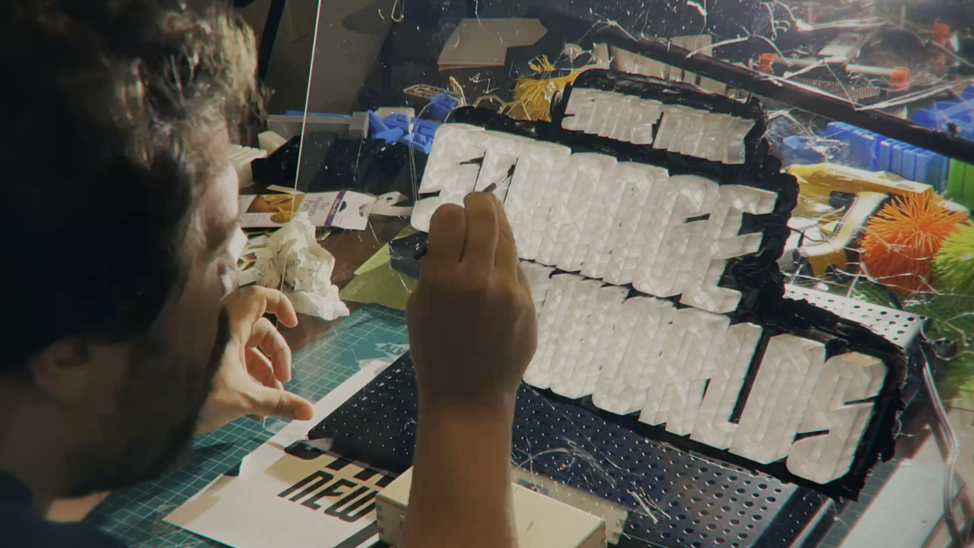 Burt painting and refining the white title-engine miniature at the workbench.