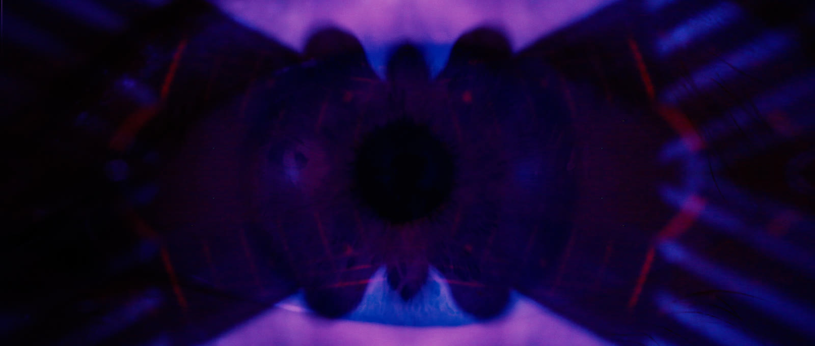 A kaleidoscopic close view of an eye and guitar strings.
