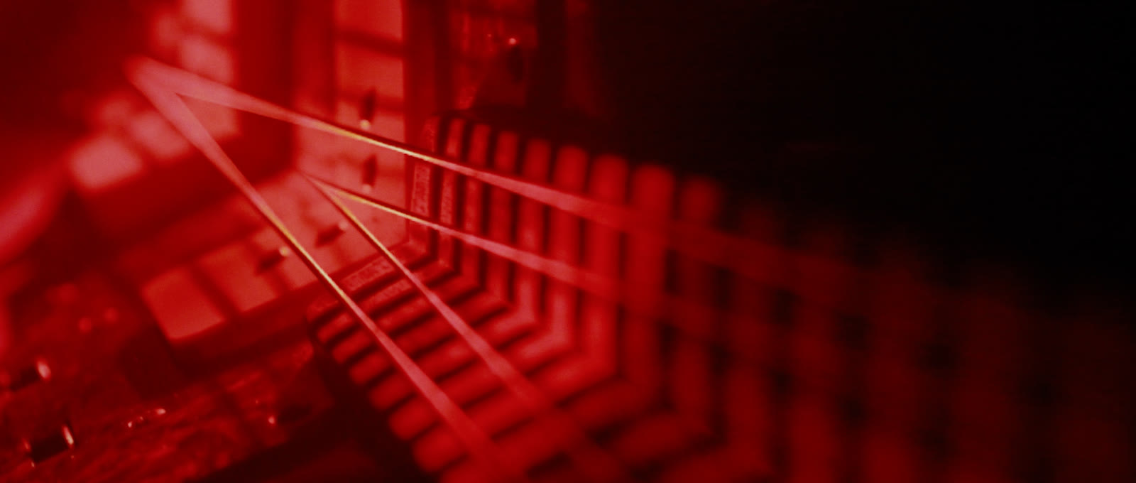 A red fretboard repeated into a rhythmic tunnel.